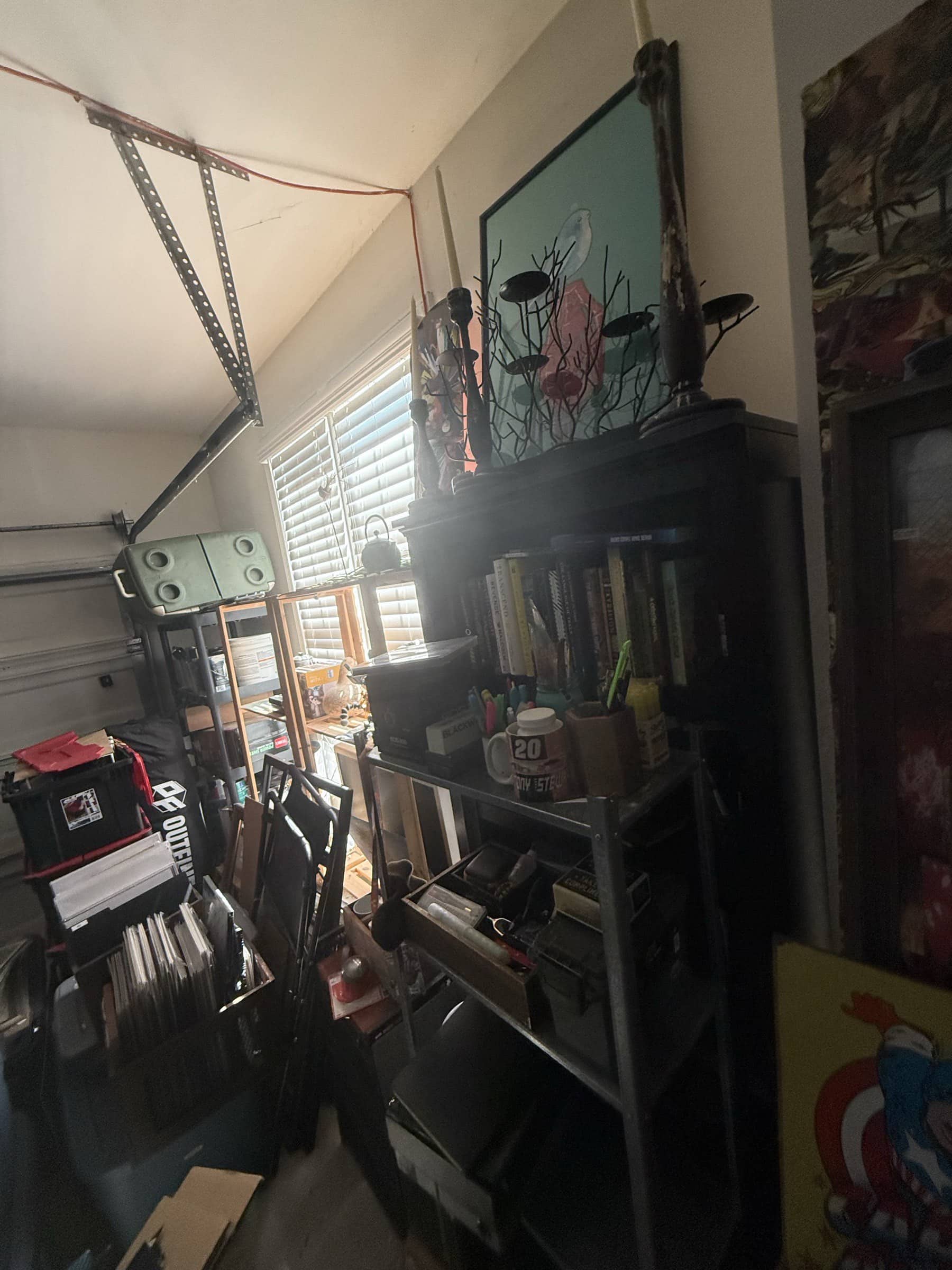 Wide view of the garage studio showing shelves, books, archive bins, and work surfaces.