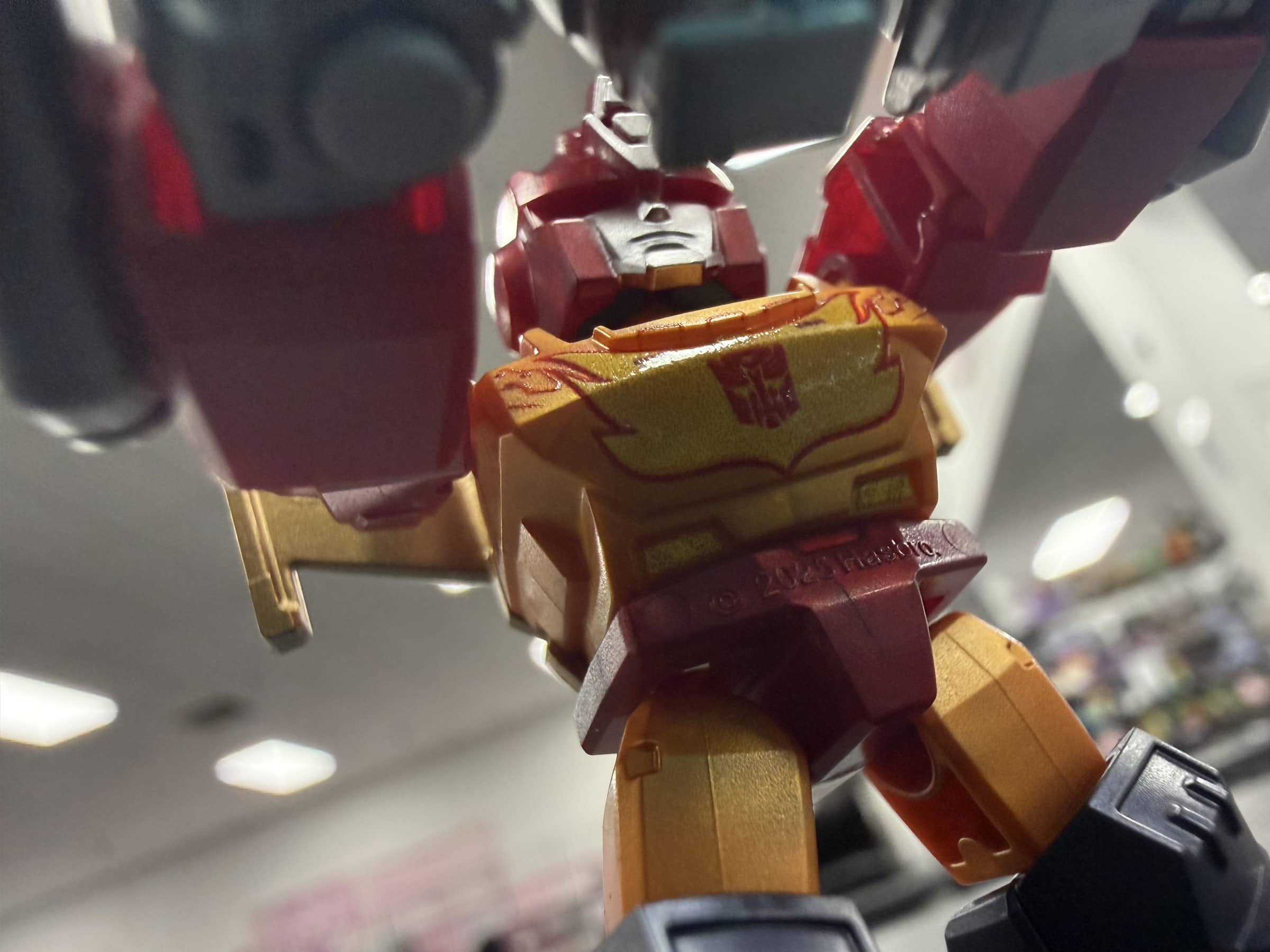 Close chest-level view of Rodimus Prime showing the Autobot insignia and metallic paint.