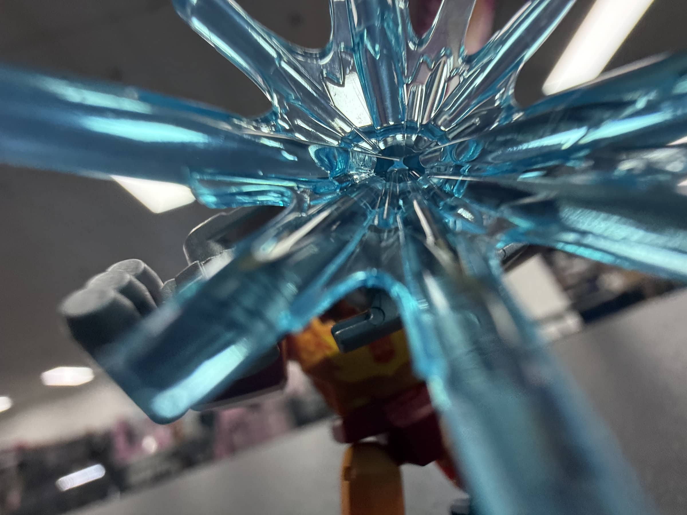 Extreme close-up through the translucent blue effect piece attached to the Rodimus figure.