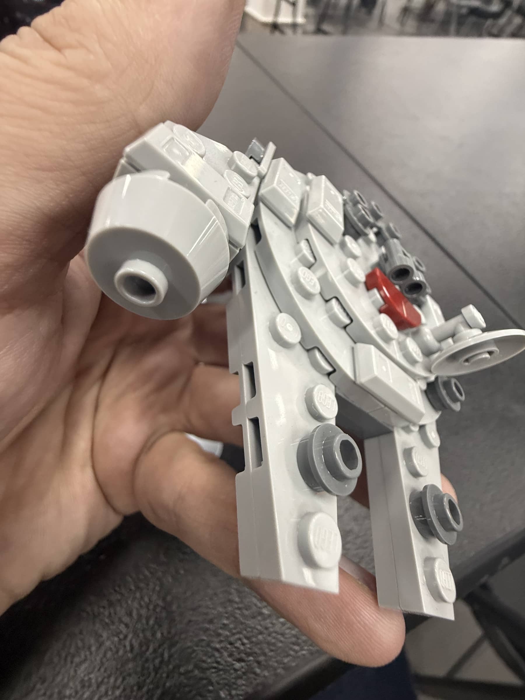 Micro LEGO Falcon held in hand during the same field visit.