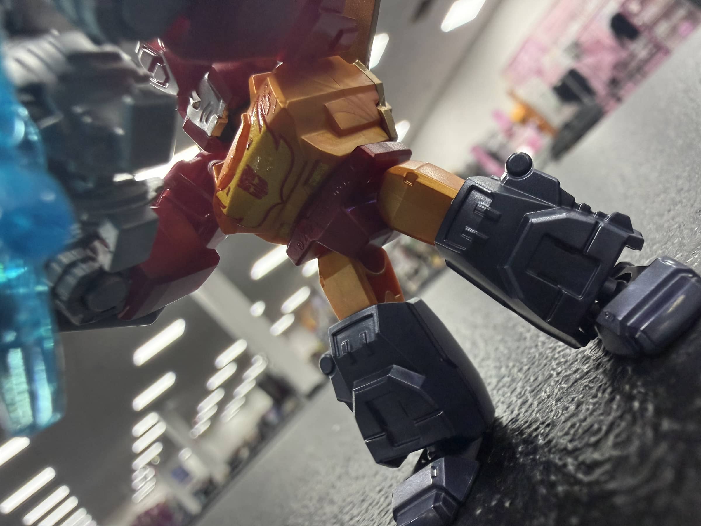 Low-angle view of the Rodimus Prime figure under Charlie's fluorescent lights.